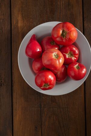 Fresh red tomatoes on a wooden background top viewの写真素材