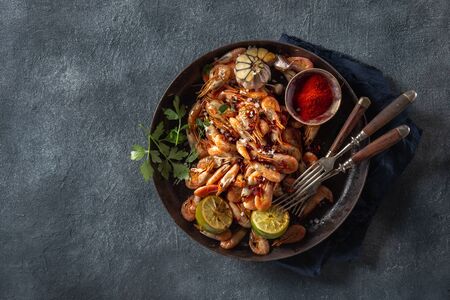 Fresh fried spiced shrimp in a frying pan on dark background top viewの写真素材