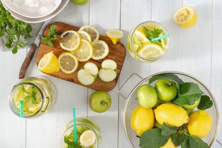 Summer drink concept. Fresh lemonade with apples and lemon on a wooden table top viewの写真素材
