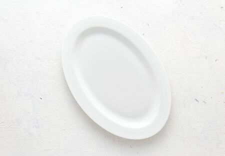 Empty white plate on a white background top viewの写真素材