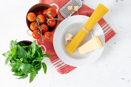 Top view raw Italian pasta with ingredients for cooking on a white background top viewの写真素材