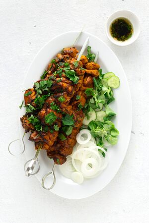 Barbeque shish kebab on a white plate on a white background top viewの写真素材