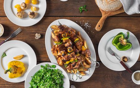 Dinner table concept. Shish kebab, vegetables and salad top viewの写真素材