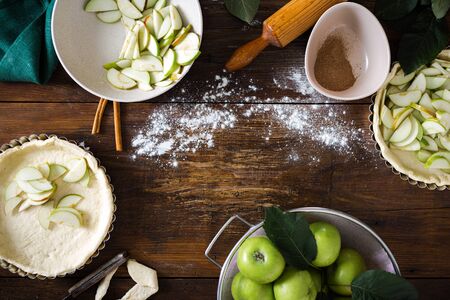Frame of ingredients for cooking homemade apple pie on wooden background top viewの写真素材