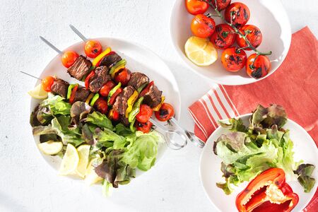 Food table with beef grilled meat kebab with vegetables and sauce top viewの写真素材