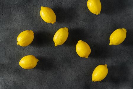 Pile of lemons on a dark background top viewの写真素材