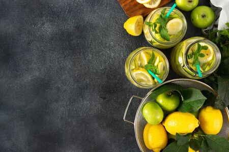 Summer drink concept. Sugar free fresh lemonade with apples and lemon on a dark background top viewの写真素材