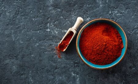 Chili pepper powder on dark stone background with free space for text top viewの写真素材