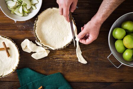 Ingredients for cooking homemade french apple tarts on wooden table top viewの写真素材