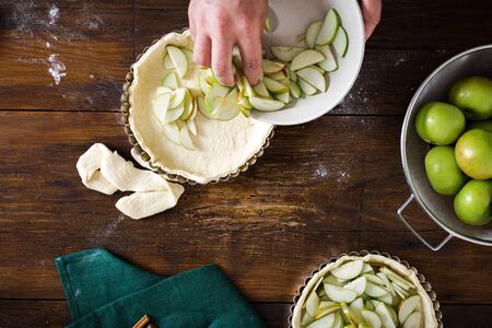 Man cooking homemade french apple pie on wooden table top viewの写真素材