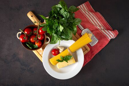 Raw pasta with ingredients for cooking Italian spaghetti on dark backgroundの写真素材