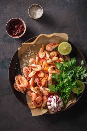 Raw prawns in a cooking pan with ingredients for preparation fried shrimps on a dark background top viewの写真素材