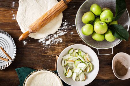 Ingredients for cooking homemade apple tarts on wooden table top viewの写真素材