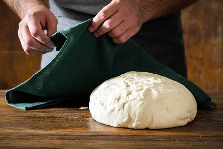 Fresh dough for preparing homemade bread on a wooden tableの写真素材