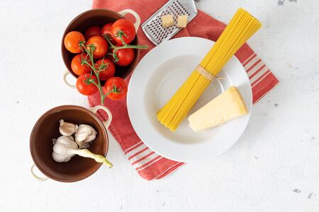 Raw Italian pasta with ingredients for cooking spaghetti on a white background top viewの写真素材