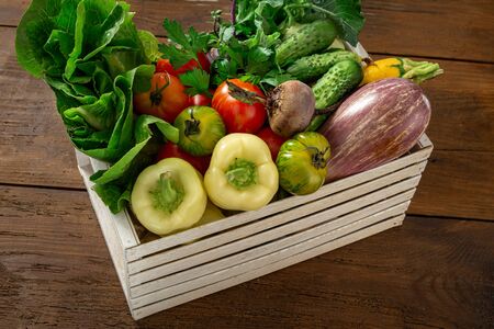 Harvesting concept. Wooden box with a bunch of different vegetables close upの写真素材