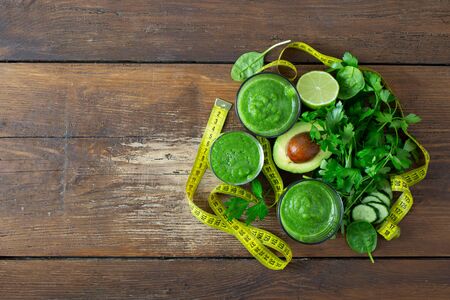 Green detox smoothie with measuring tape on wooden  detox juices conceptの写真素材