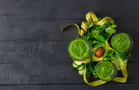 Overhead view green detox smoothie with measuring tape on wooden  food detox conceptの写真素材