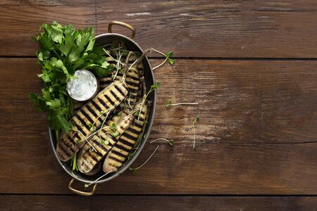 Grilled eggplant in a pan with sauce on wooden  with copy spaceの写真素材