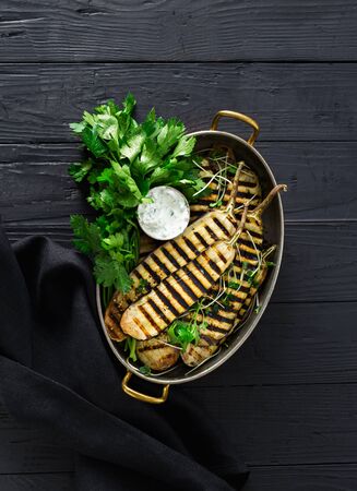 Grilled eggplant in a pan on dark woodenの写真素材