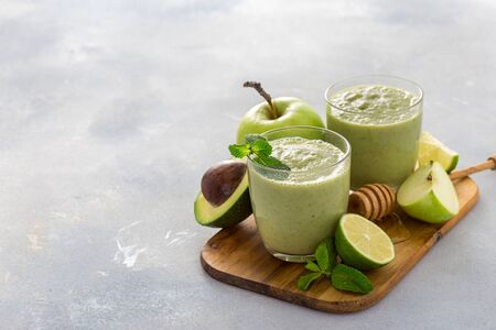 Healthy clean eating concept, Breakfast green juice smoothie of apple spinach lime avocado and honey on a table with copy spaceの写真素材