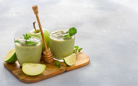 Breakfast green juice smoothie of apple spinach lime and honey on a table with copy space Healthy clean eating conceptの写真素材