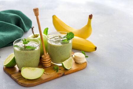Healthy clean eating concept Glass mug with green health smoothie of apple spinach lime and honey on a table with copy spaceの写真素材