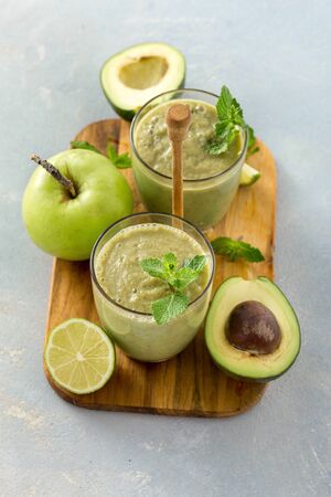 Healthy clean eating concept Glass mug with green health smoothie of apple spinach lime and avocado on a tableの写真素材