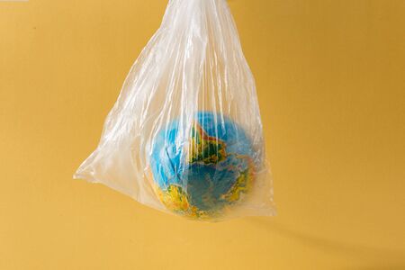 Save our planet or World Environment Day concept concept Earth in a plastic bagの写真素材