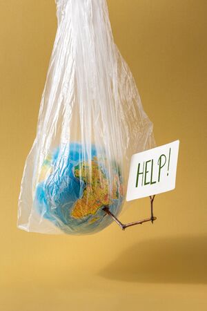 World Environment Day concept Earth holds card with the inscription helpの写真素材