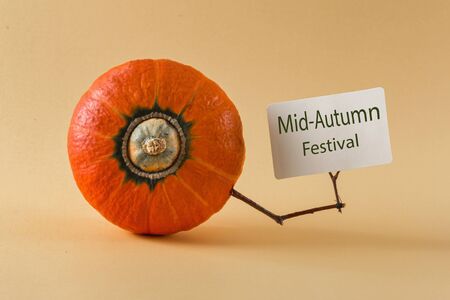 Mid autumn festival concept hokkaido pumpkin holds card with inscriptionの写真素材