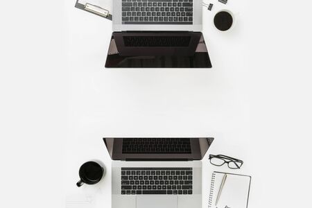 Minimal freelancer office workplace flat lay top view Worksplase with laptop, notebook, pen, glasses and coffee cupの写真素材