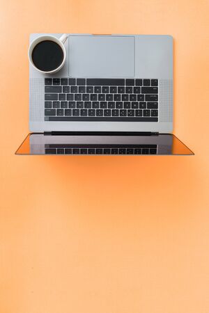 Home office workspace with laptop and cup of coffeeの写真素材