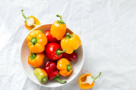Yellow and red bell peppers in plate on white background top viewの写真素材