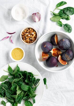 Raw ingredients for cooking vegetarian salad of figs, nuts and spinach top viewの写真素材