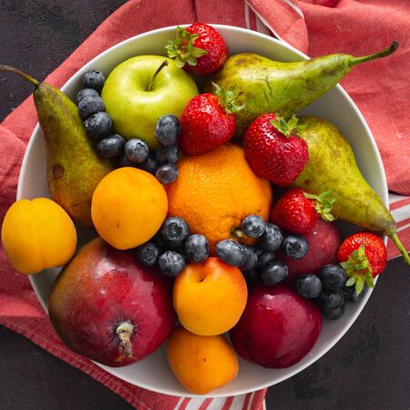 Fruits plate on a dark background top viewの写真素材