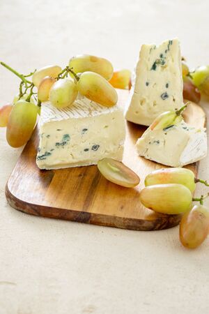 Bavaria blue cheese with grapes on a wooden board close upの写真素材