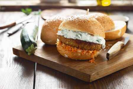 Vegetarian burger on a wooden cutting boardの写真素材