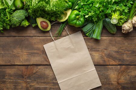 Shopping bag with green vegetables on wooden background Purchase healthy foodの写真素材