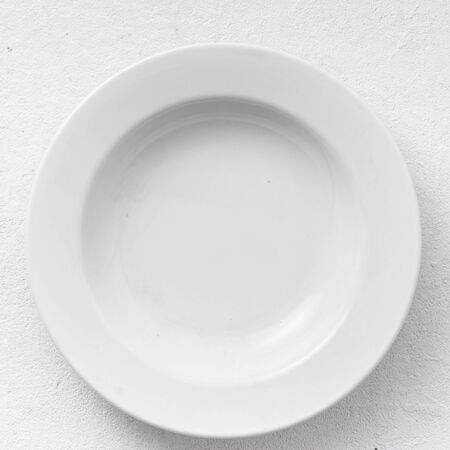 Empty white round plate on a white background top viewの写真素材