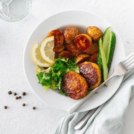 Lunch plate with healthy food Fresh vegetarian cutlets with new potatoes and salad on a white background top viewの写真素材