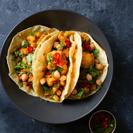 Tortilla with aloo gobi and chickpeas on dark background top viewの写真素材