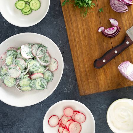 Healthy food. Raw ingredients cooking summer salad with radishes, cucumber and yogurt top viewの写真素材