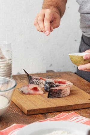 Man prepares carp river fish in home kitchen. Cooking healthy and diet foodの写真素材
