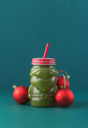 Zero waste concept. Green fruit smoothie on blue background in glass santa claus jar. Healthy and diet food conceptの写真素材