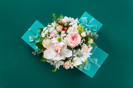 Flower bouquet with gift on green background Flat lay, top view. St. Valentine's Day, Love conceptの写真素材