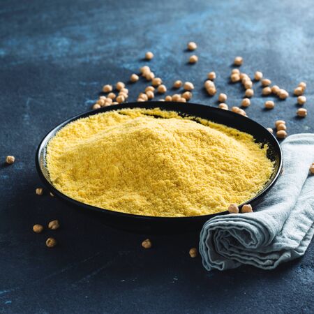 Chickpea flour in black ceramic bowl on dark background copy spaceの写真素材