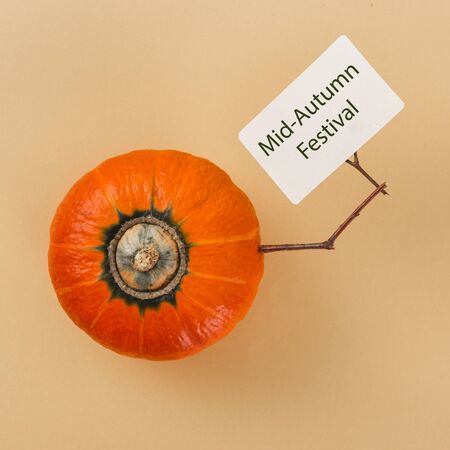 Hokkaido pumpkin holds card with inscription mid autumn festival top viewの写真素材
