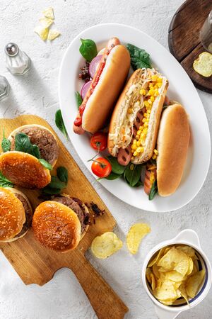 Party dinner table with different homemade hot dogs and burgers top viewの写真素材