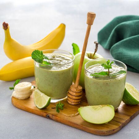 Weight loss clean eating healthy dieting food Green smoothie drink detox of apple banana limeの写真素材